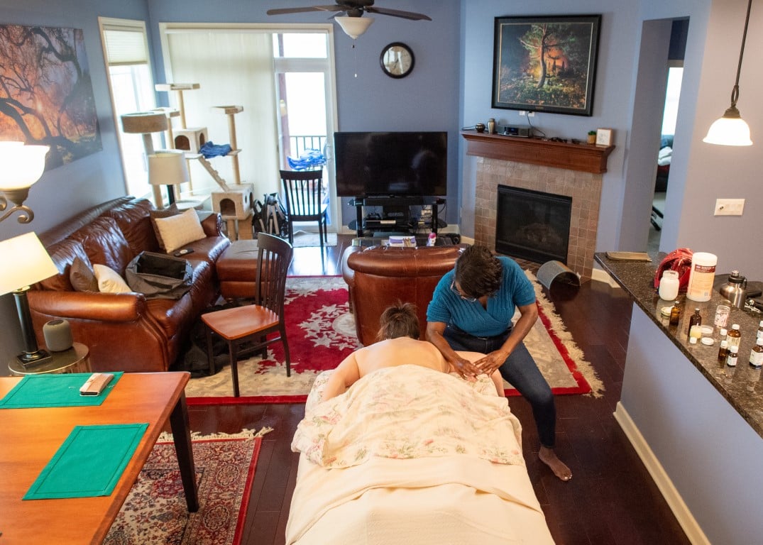 Wide view of Widlyne performing massage in a client's home